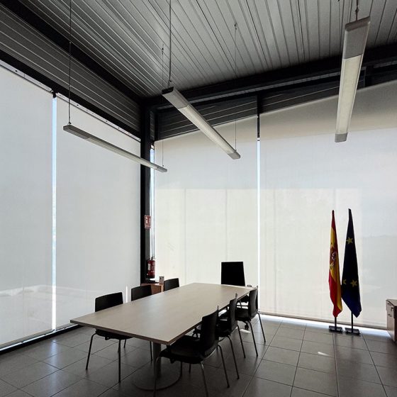 Sala de juntas con estores manuales Bandalux a medida. Mesa de juntas, sillón de dirección y sillas